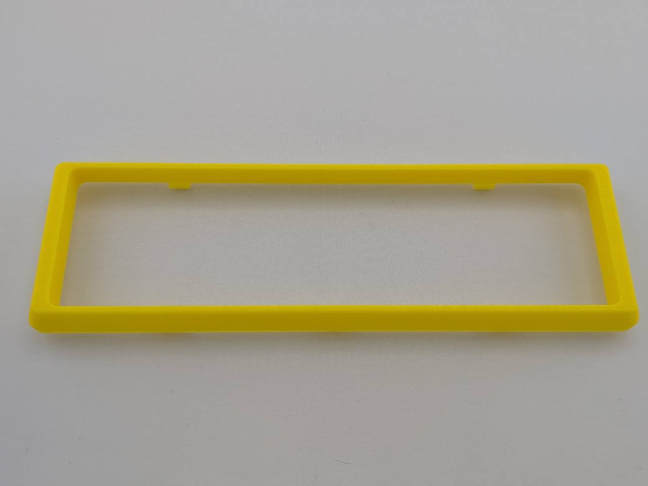 Yellow Alpine CD radio replacement bezel trim ring mounting tab close-up