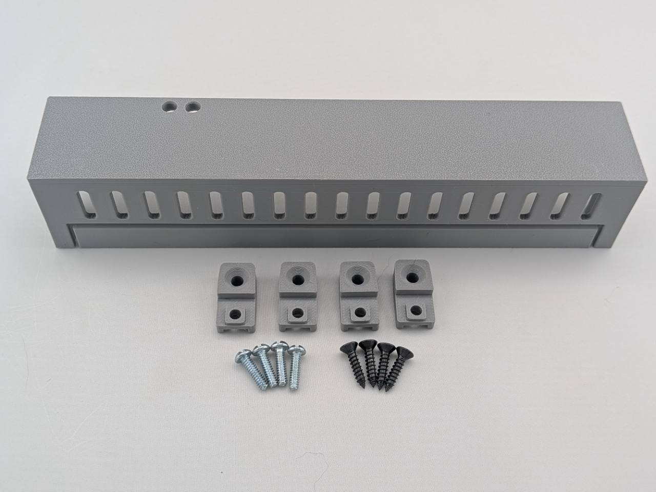 Gray Kicker amplifier cover mounting feet kit with four silver screws and four black screws