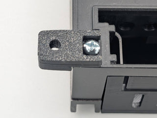 Close-up of a silver amplifier-attachment screw securing a Black TightPrints mounting foot; amplifier and TightPrints detachable plate shown for fitment only and not included