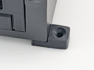 Close-up of the countersunk mounting-surface hole on a Black TightPrints amplifier mounting foot; amplifier and TightPrints detachable plate shown for fitment only and not included