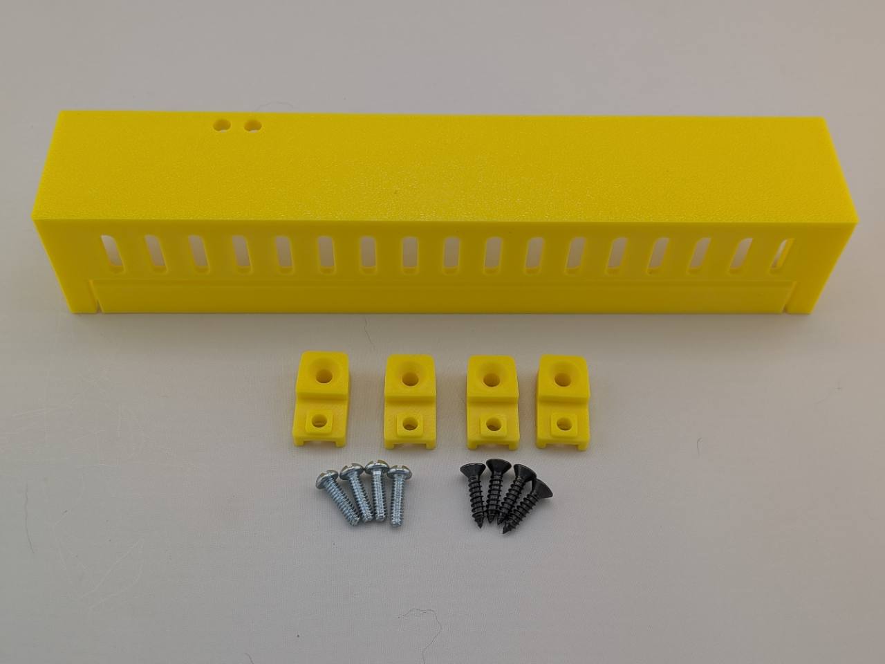 Yellow Kicker amplifier cover mounting feet kit with four silver screws and four black screws
