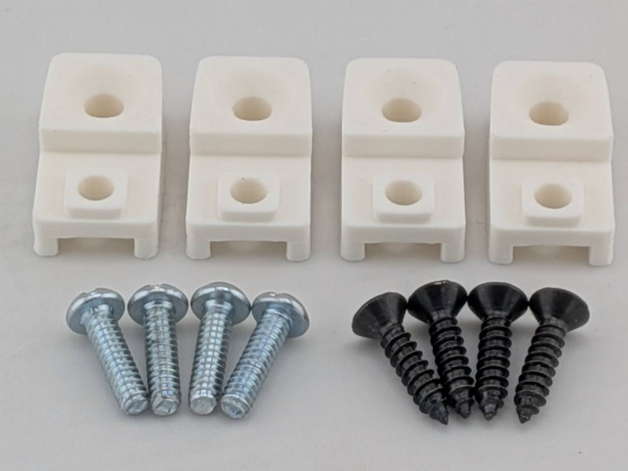 White TightPrints replacement amplifier mounting feet kit for compatible Kicker Stillwater Designs amplifiers, showing four feet and eight included screws