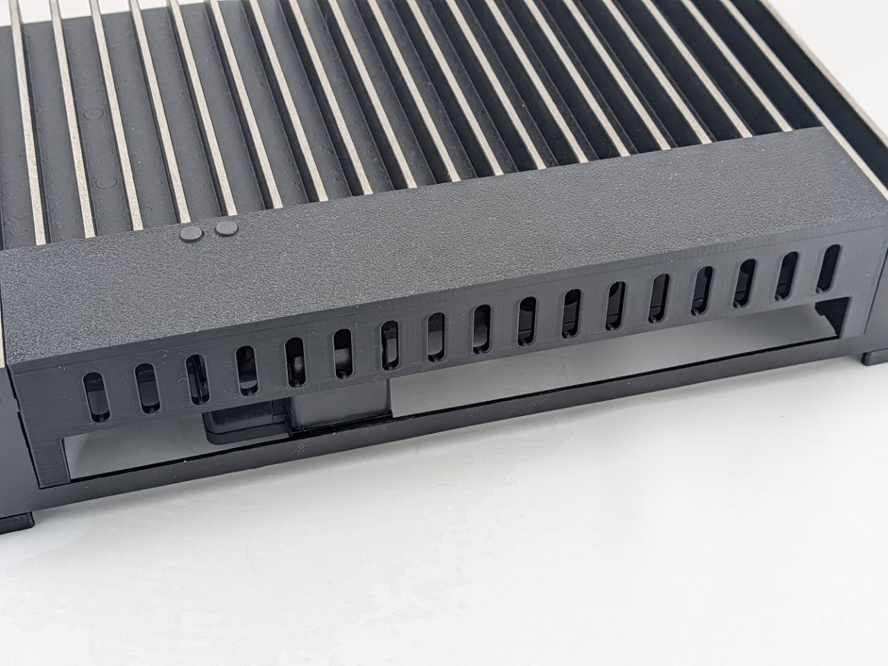Black Kicker amplifier terminal cover installed on a compatible amplifier with lower wire access open; amplifier, mounting feet, screws, and hardware are not included, and the integrated breakaway panel ships attached