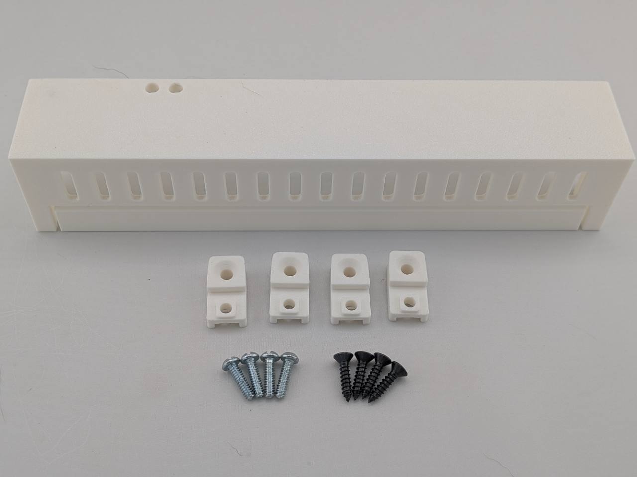 White Kicker amplifier cover mounting feet kit with four silver screws and four black screws