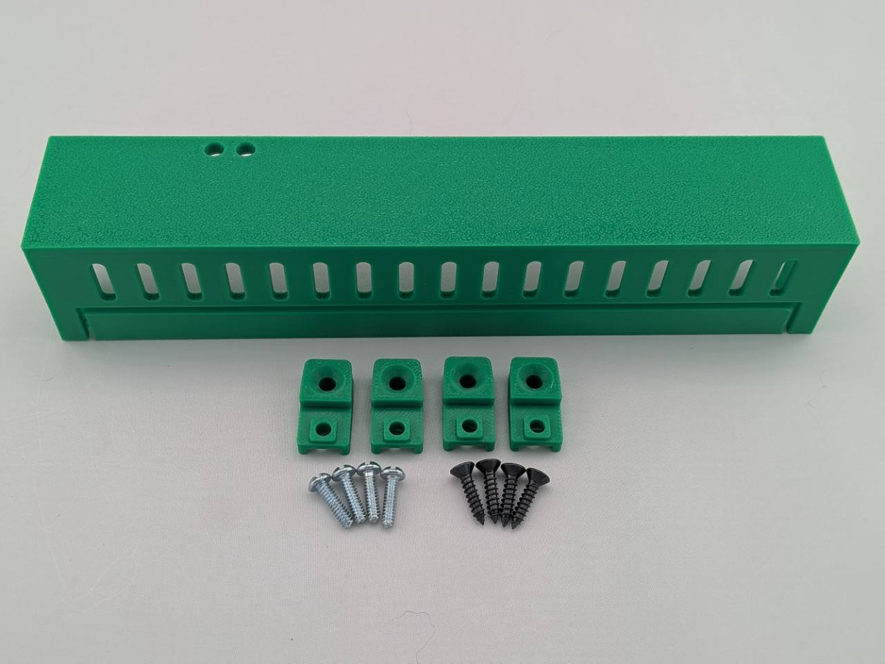 Green Kicker amplifier cover mounting feet kit with four silver screws and four black screws