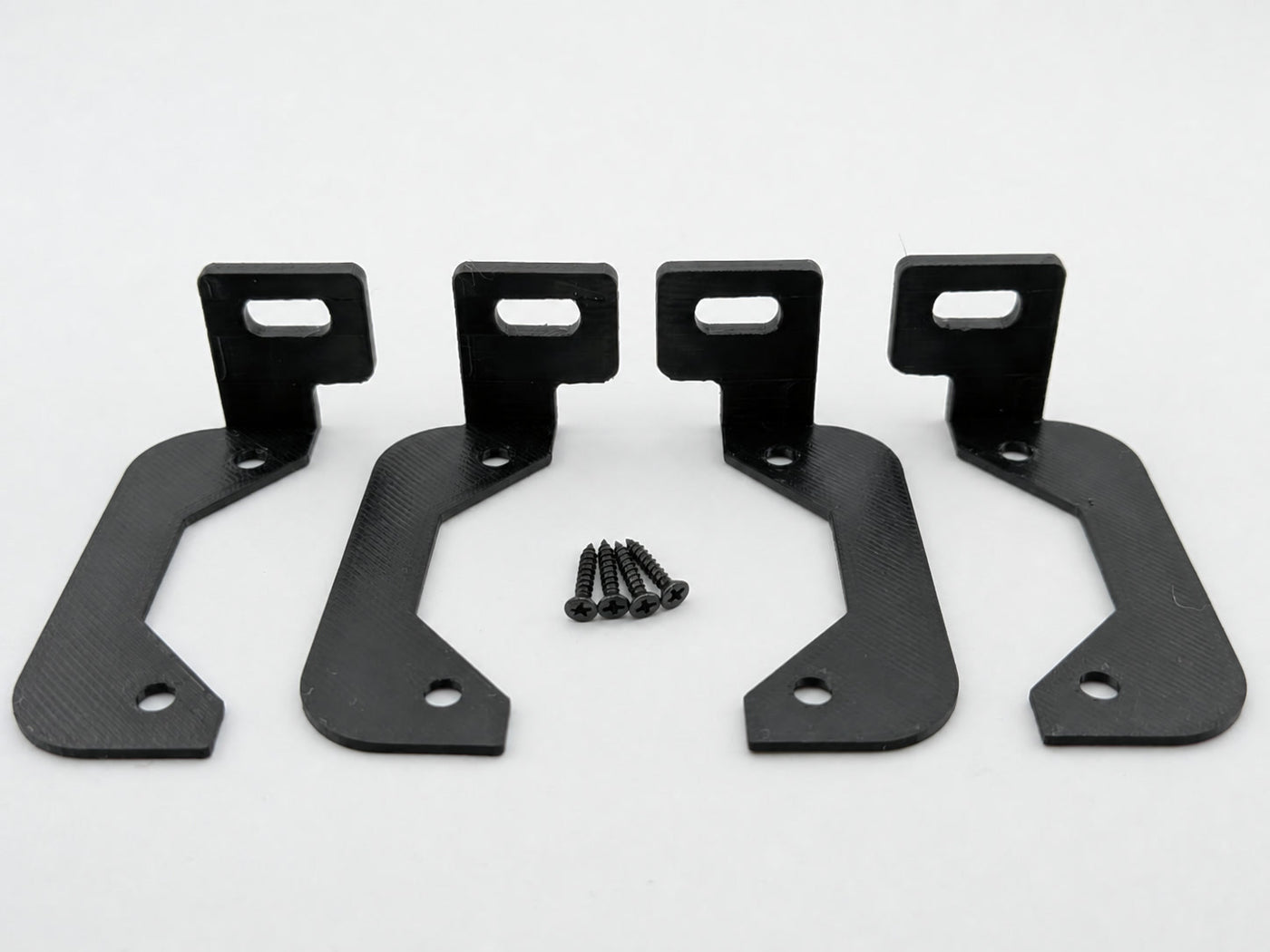 Four Black ABS horizontal amplifier mounting feet with four included mounting screws on a white background