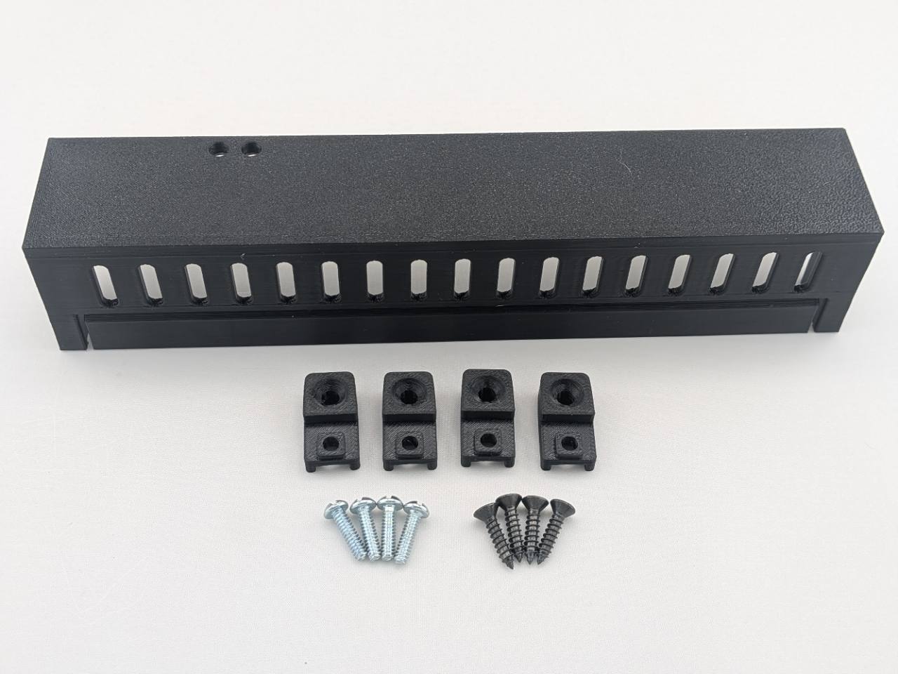Black Kicker amplifier cover mounting feet kit with four silver screws and four black screws