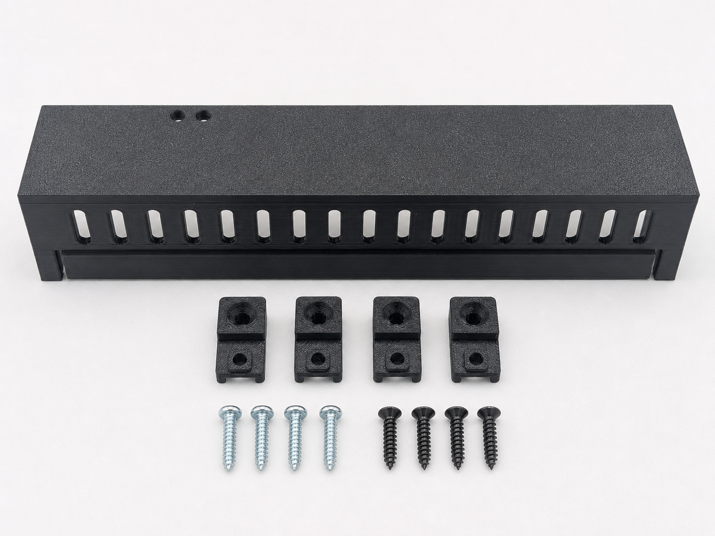 Aligned front view of Black Kicker amplifier cover mounting feet kit with four silver screws and four black screws